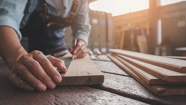 Mann måler opp en list som skal monteres